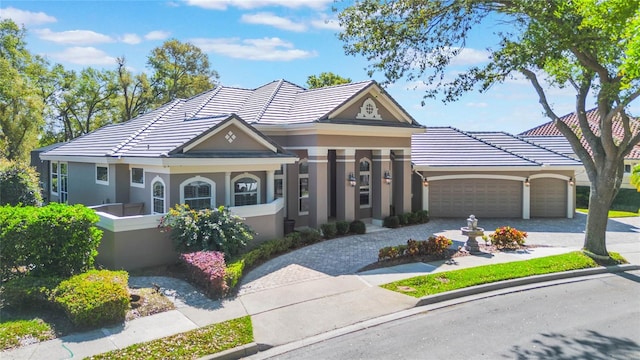 view of front of property with a tile roof, decorative driveway, and stucco siding