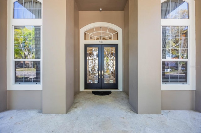 doorway to property featuring stucco siding and french doors