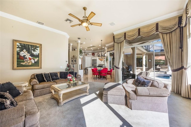 living area featuring visible vents, decorative columns, ornamental molding, ceiling fan, and light colored carpet