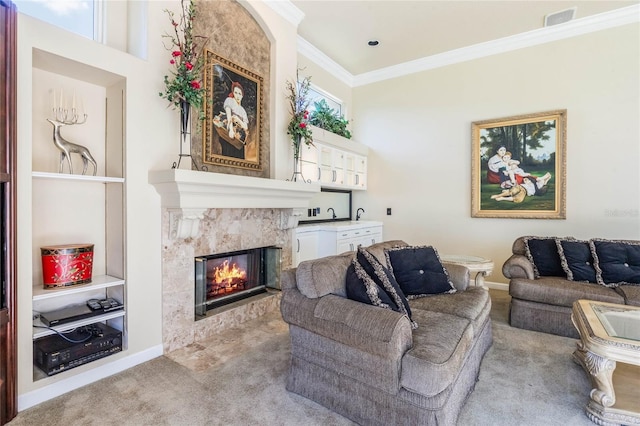 living room with baseboards, visible vents, ornamental molding, a tiled fireplace, and carpet flooring