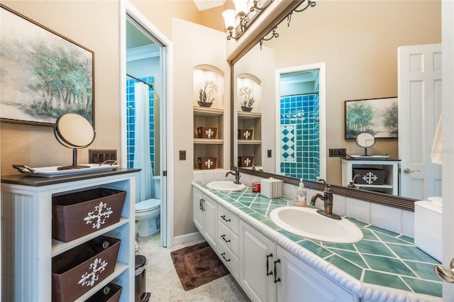 full bath with a sink, toilet, and double vanity