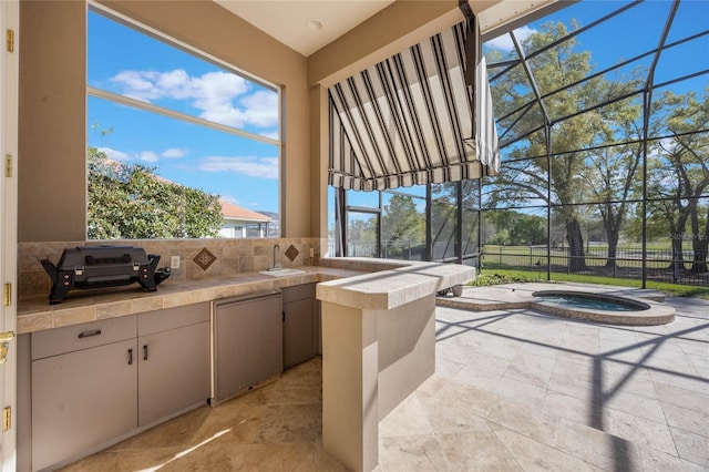 view of patio featuring a lanai, area for grilling, fence, and an in ground hot tub