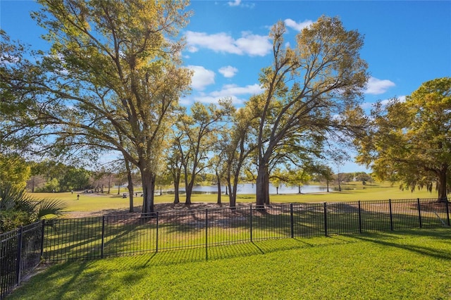 view of yard featuring fence and a water view