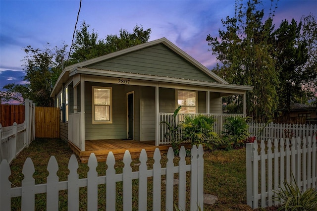 view of front of property with a fenced front yard and a porch