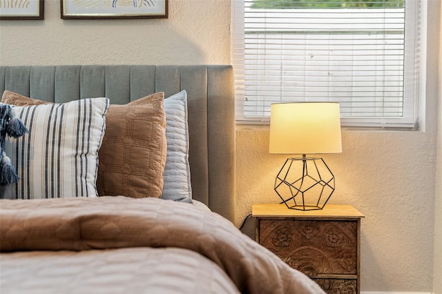 bedroom featuring multiple windows and a textured wall