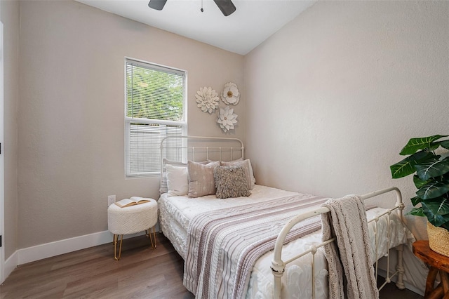 bedroom featuring ceiling fan, lofted ceiling, baseboards, and wood finished floors