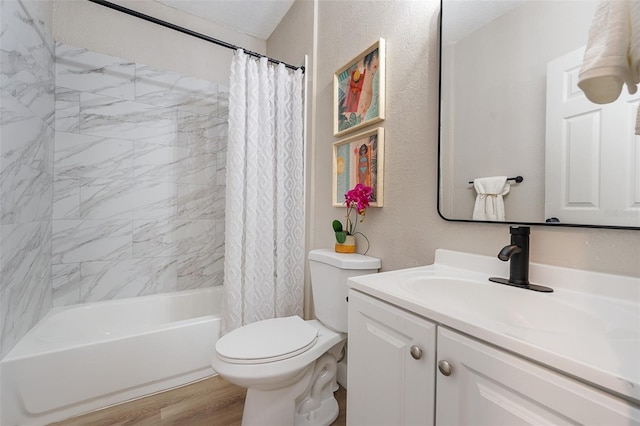 bathroom featuring toilet, shower / tub combo with curtain, wood finished floors, a textured wall, and vanity