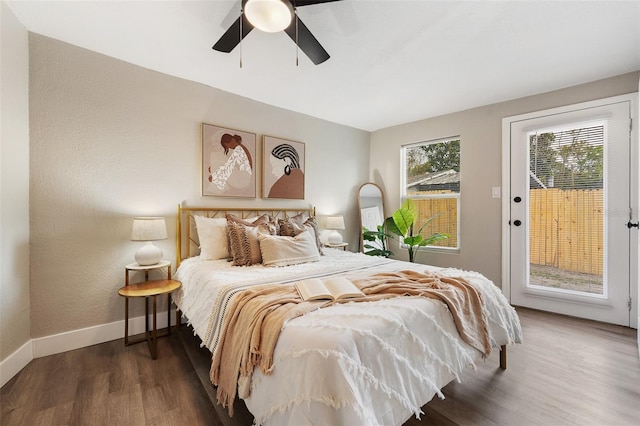 bedroom featuring access to exterior, ceiling fan, baseboards, and wood finished floors