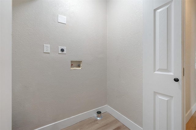 clothes washing area featuring hookup for a washing machine, wood finished floors, baseboards, hookup for an electric dryer, and laundry area