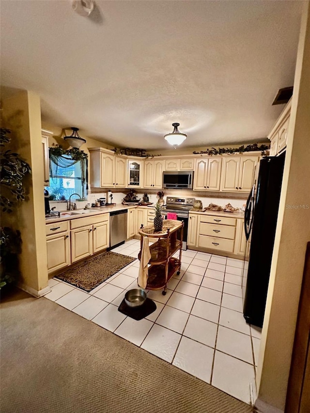 kitchen featuring light tile patterned floors, visible vents, stainless steel appliances, and a sink