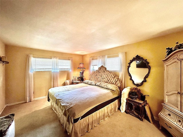 bedroom with baseboards and light carpet