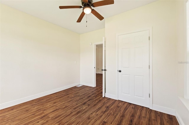 unfurnished bedroom featuring dark wood-type flooring, baseboards, and ceiling fan