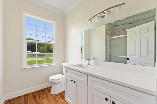 bathroom featuring vanity, wood finished floors, ornamental molding, a shower stall, and toilet