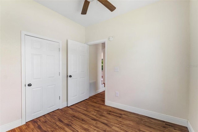 unfurnished bedroom with ceiling fan, wood finished floors, visible vents, and baseboards