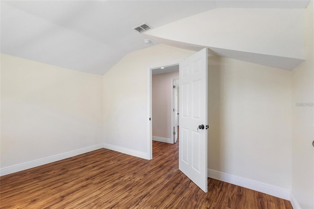 additional living space with visible vents, lofted ceiling, baseboards, and wood finished floors