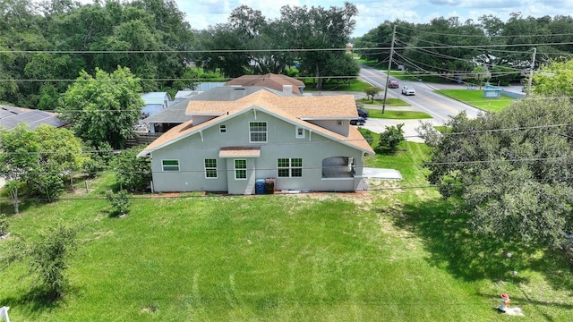 back of house with a yard and central AC