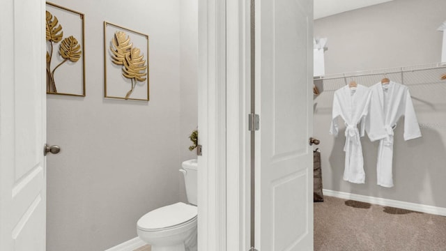 bathroom with baseboards and toilet