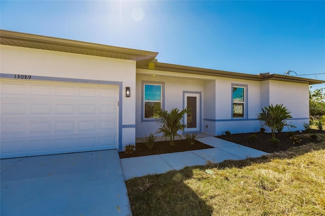 view of front of property with a garage, driveway, and stucco siding