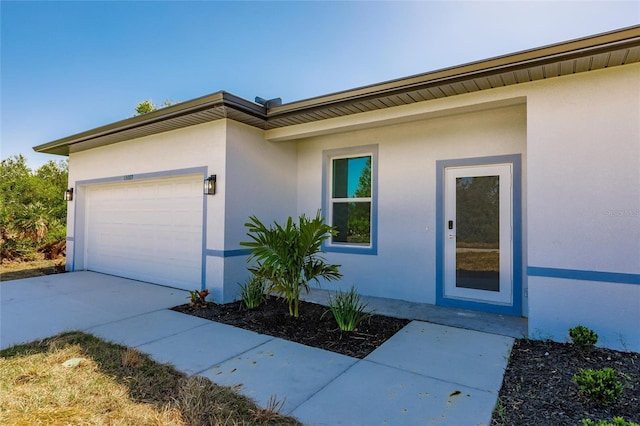 exterior space featuring concrete driveway, a garage, and stucco siding