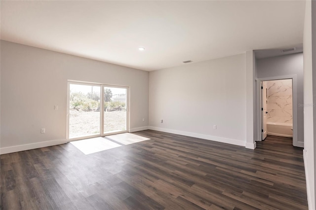 empty room with visible vents, dark wood-style floors, and baseboards