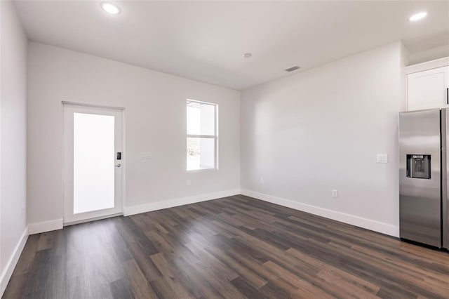 empty room featuring recessed lighting, visible vents, baseboards, and dark wood-style floors