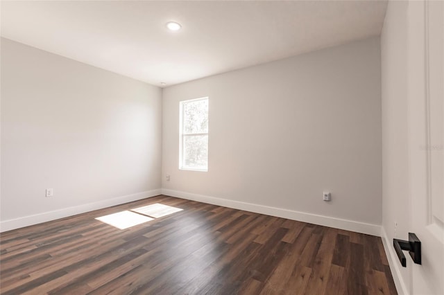 empty room featuring dark wood finished floors and baseboards