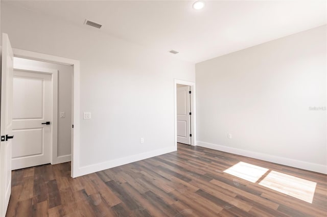 spare room with recessed lighting, visible vents, baseboards, and dark wood-type flooring