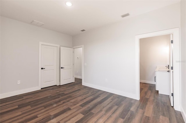 spare room with dark wood finished floors, baseboards, and visible vents