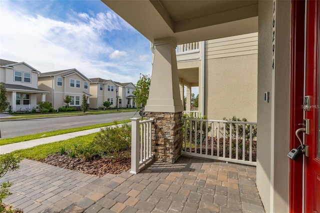 exterior space with covered porch, a residential view, and stucco siding