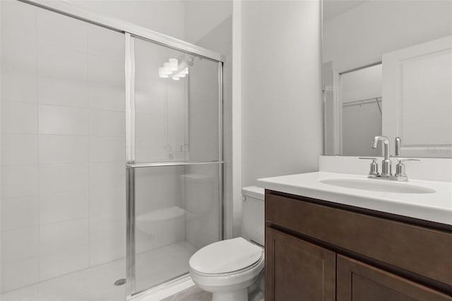 full bathroom featuring a shower stall, toilet, and vanity