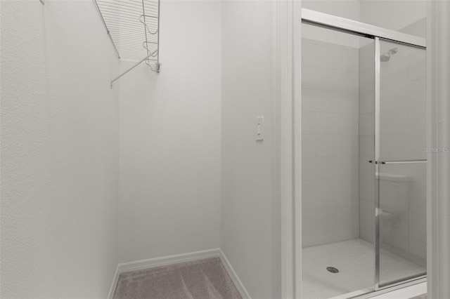 full bath with a shower stall and baseboards