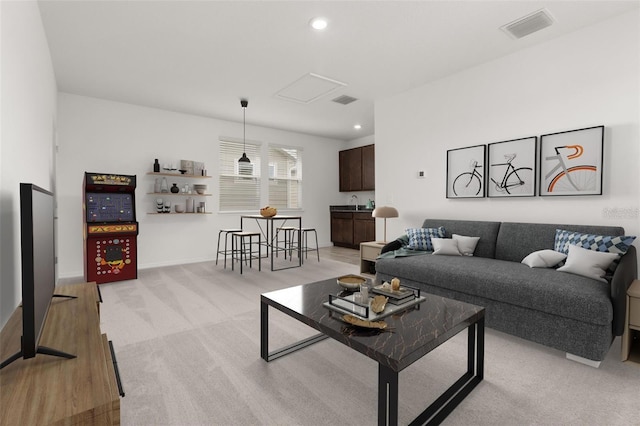 living room featuring recessed lighting, visible vents, light carpet, and attic access