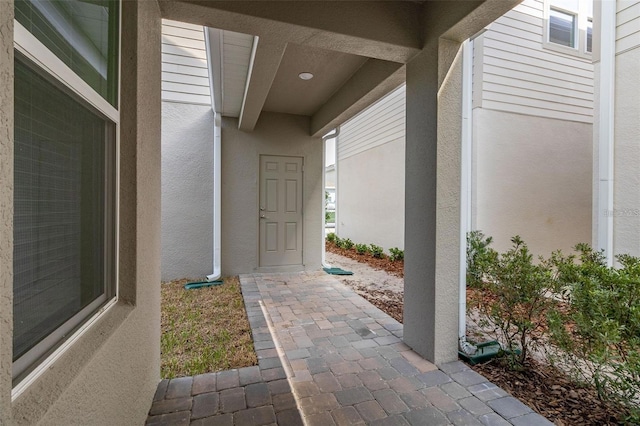 entrance to property featuring stucco siding