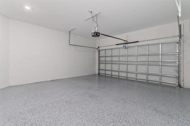 garage with concrete block wall and a garage door opener