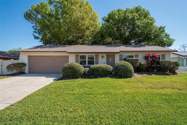 ranch-style home featuring an attached garage, driveway, a front yard, and fence