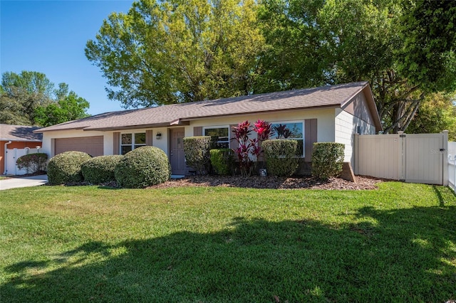 ranch-style house with a front yard, fence, a garage, and a gate