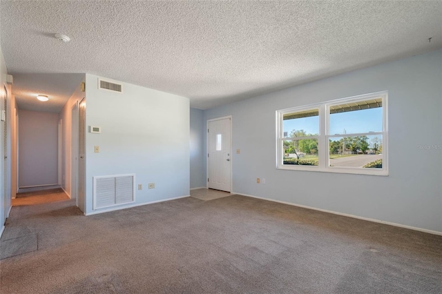 unfurnished living room featuring baseboards, visible vents, and carpet floors