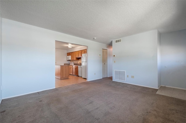 unfurnished living room with visible vents, baseboards, and light colored carpet