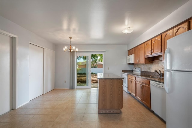 kitchen with light tile patterned floors, white appliances, a notable chandelier, and a sink