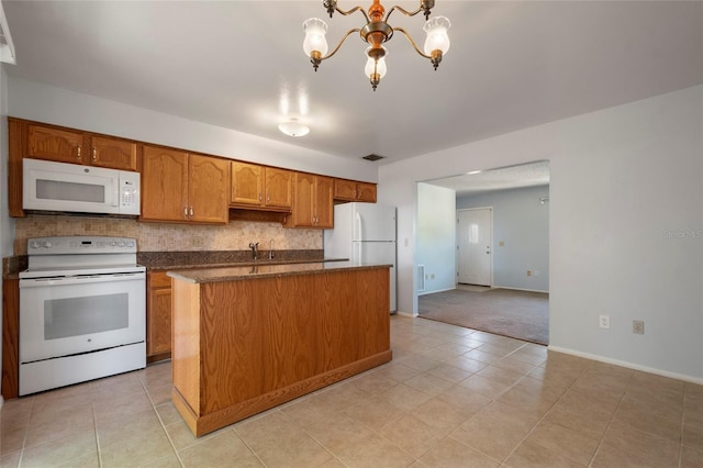 kitchen featuring white appliances, brown cabinetry, an inviting chandelier, tasteful backsplash, and a center island