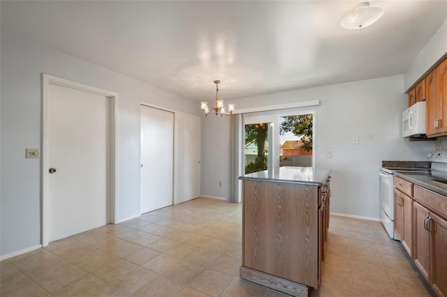 kitchen featuring dark countertops, white appliances, light tile patterned flooring, brown cabinetry, and a chandelier