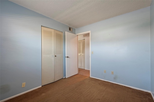 unfurnished bedroom with visible vents, baseboards, carpet floors, a closet, and a textured ceiling