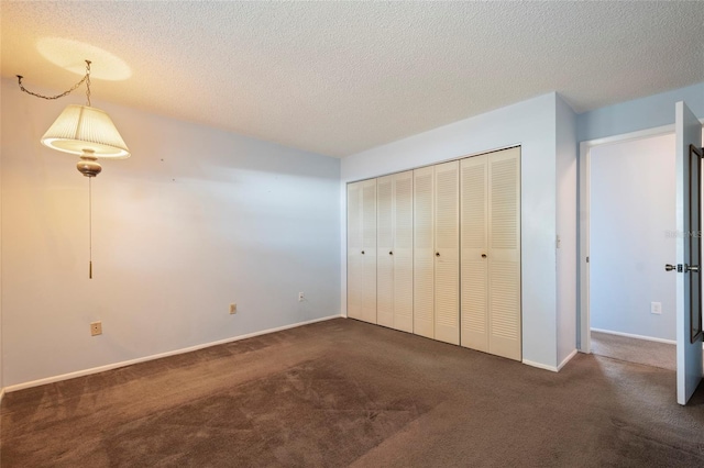 unfurnished bedroom featuring a closet, baseboards, carpet floors, and a textured ceiling