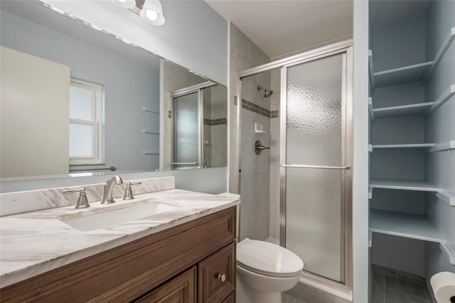 full bathroom featuring tile patterned flooring, a stall shower, toilet, and vanity