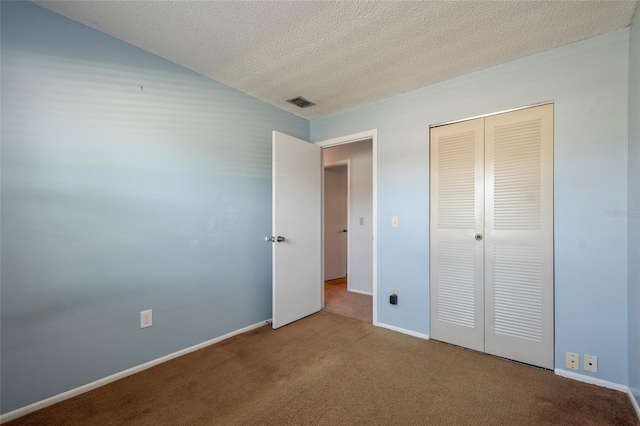 unfurnished bedroom with baseboards, visible vents, carpet floors, a closet, and a textured ceiling