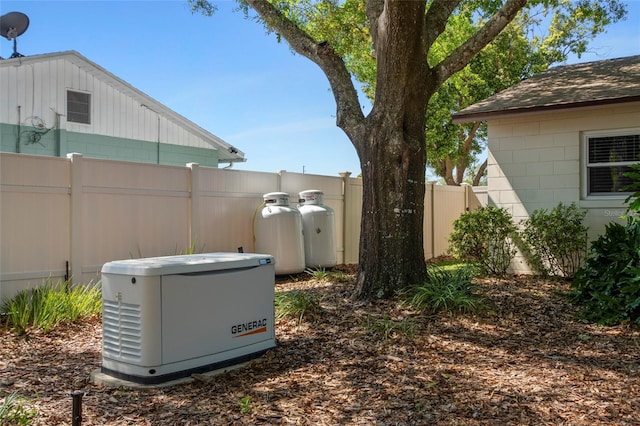 details featuring a power unit, roof with shingles, heating fuel, and fence