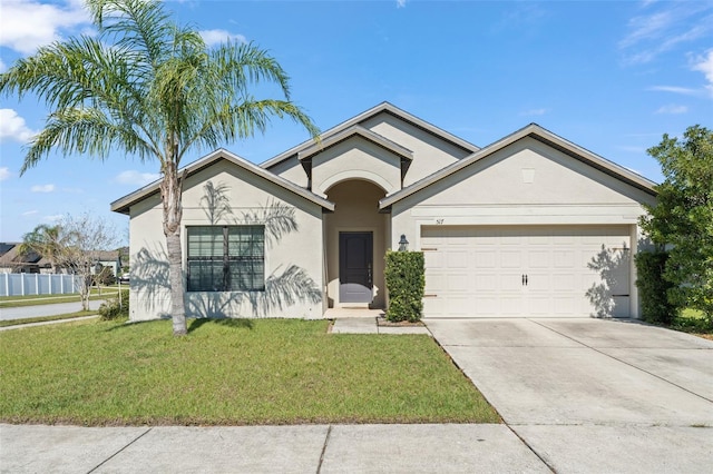 ranch-style home with stucco siding, fence, concrete driveway, a front yard, and a garage