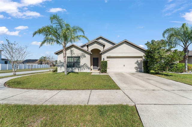 view of front of house with a front yard, fence, driveway, stucco siding, and a garage