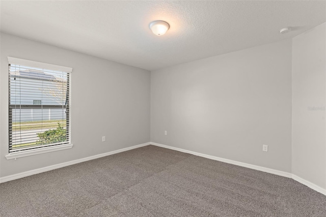 unfurnished room featuring a textured ceiling, baseboards, and carpet floors