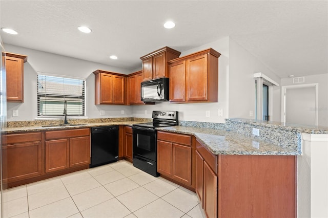 kitchen with black appliances, a sink, recessed lighting, a peninsula, and light stone countertops